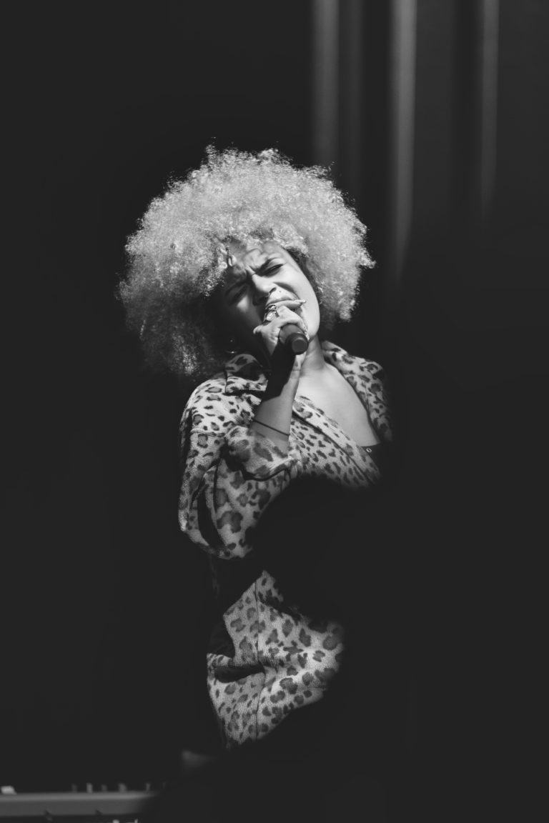 Photographie de concert, une femme chante lors des Crimson Sessions organisées par Communale à Saint Ouen