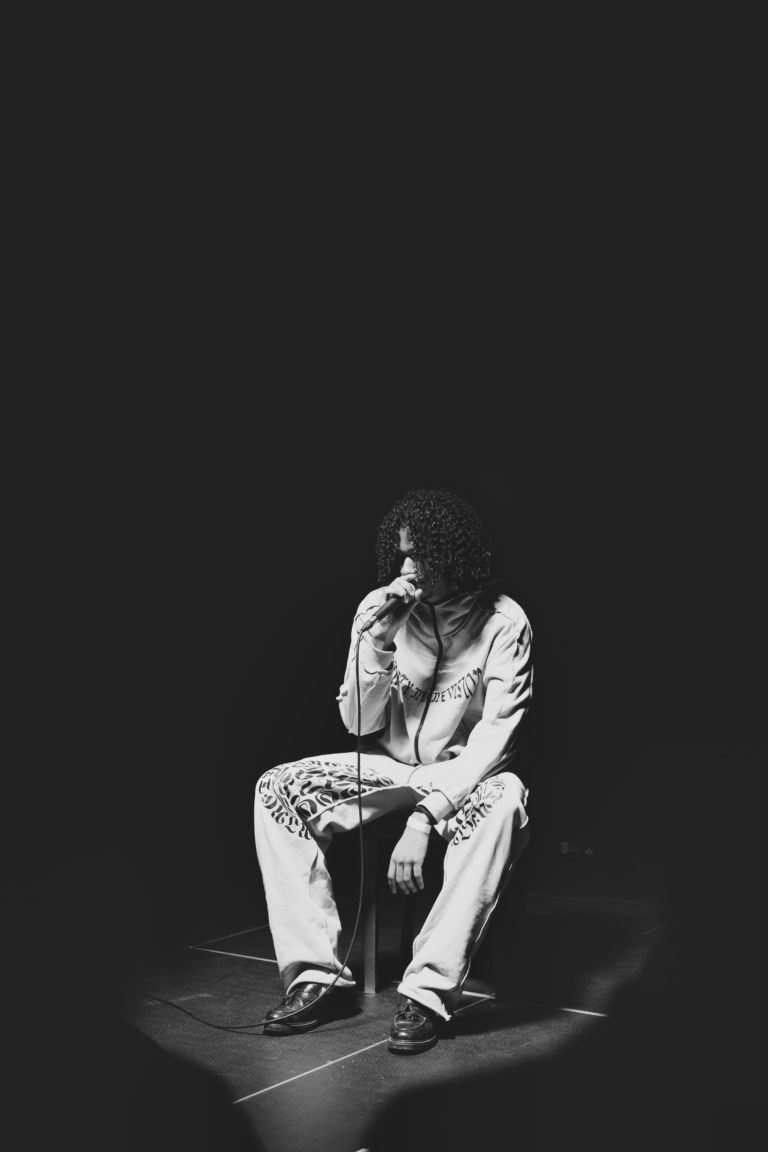 Photographie de concert, un homme chante lors des Crimson Sessions organisées par Communale à Saint Ouen