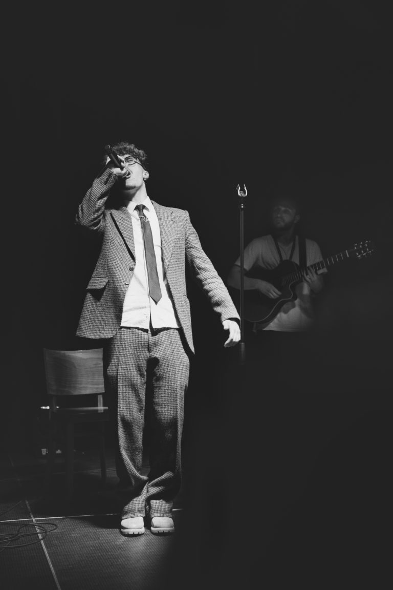 Photographie de concert, un homme chante lors des Crimson Sessions organisées par Communale à Saint Ouen