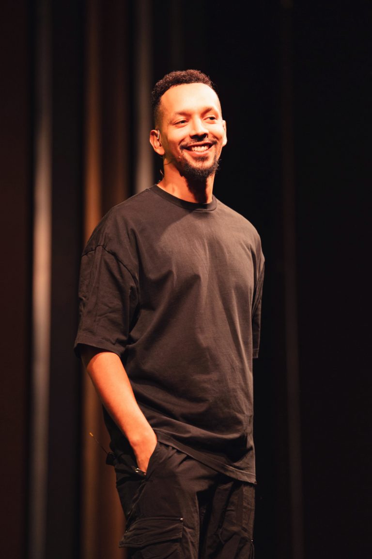 Waly Dia sourit sur scène lors de l'événement "La CoMMedy" organisé par Communale à Saint Ouen.