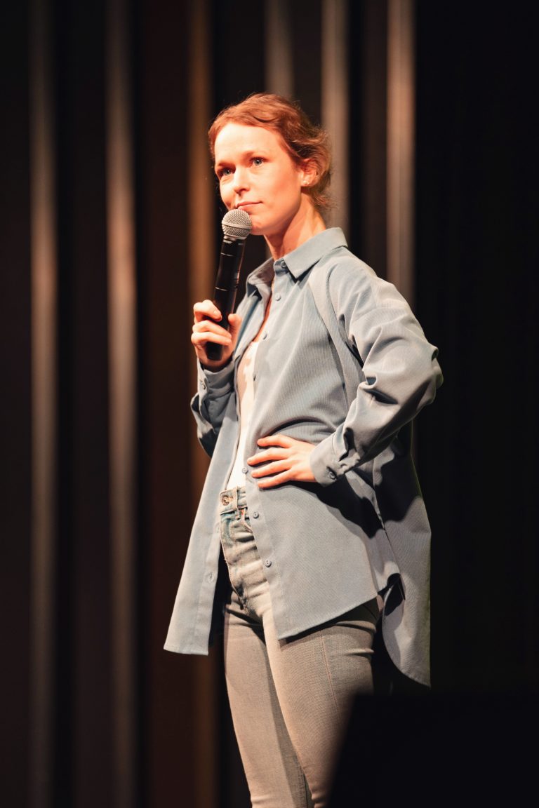 Une humoriste sur scène lors de l'événement "La CoMMedy" organisé par Communale à Saint Ouen.